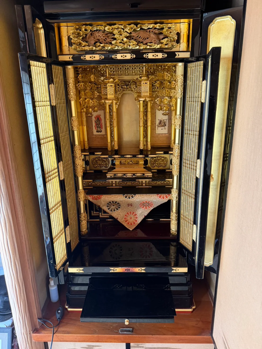 広島市安佐北区あさひが丘で買取した、茶色の鳥の彫刻と金色の柱・吊り飾りがあり、仏間に納められた金仏壇の正面