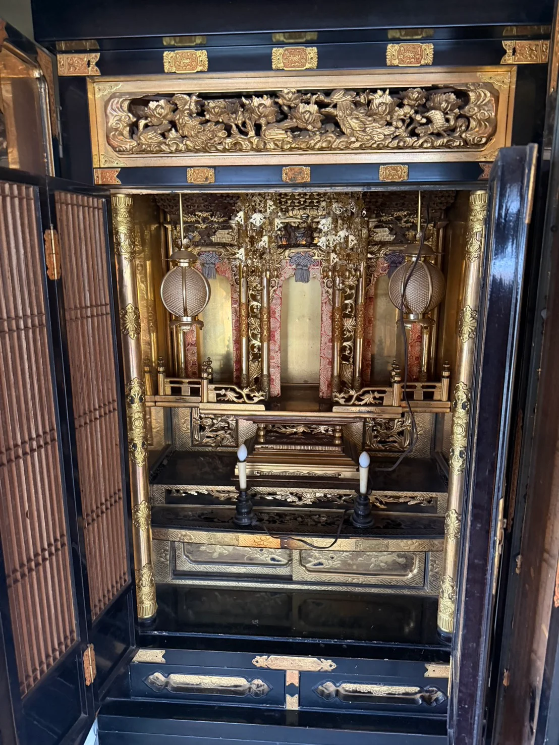 世羅郡世羅町で買取した、花や鳥の彫刻がある横長の欄間と、丸みのある一対の吊り灯籠、赤系の縁取りが見られる金仏壇